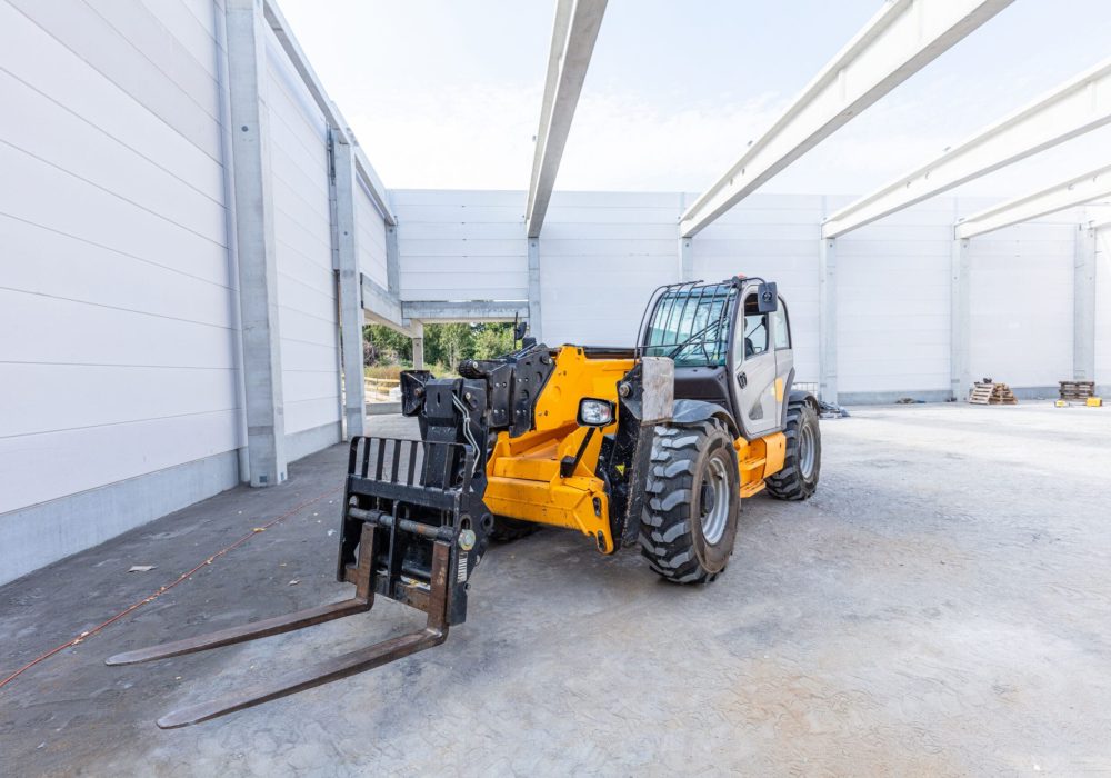 Industrial warehouse construction. Rotating telehandler vehicle. Building a new hall or storehouse.
