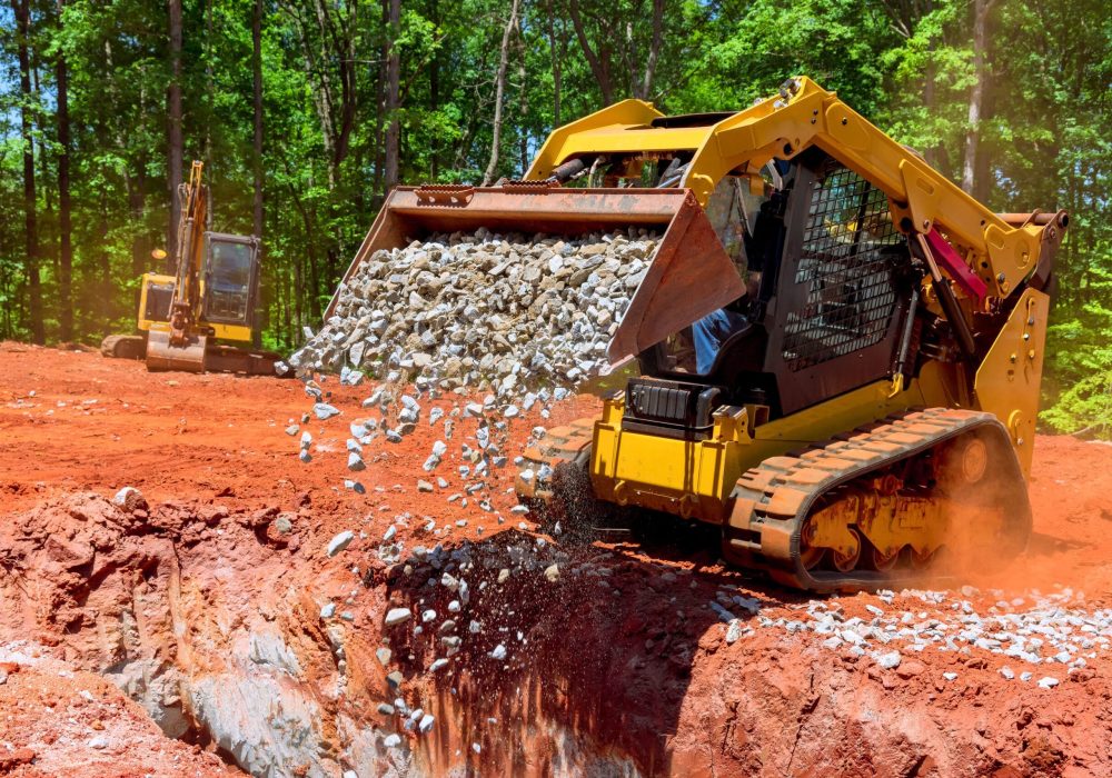 Unloading gravel with an excavator bucket skid steer loader during construction project